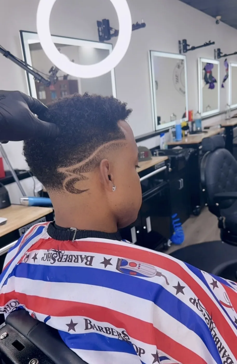 Fade with a shaved design in the side of a client's hair