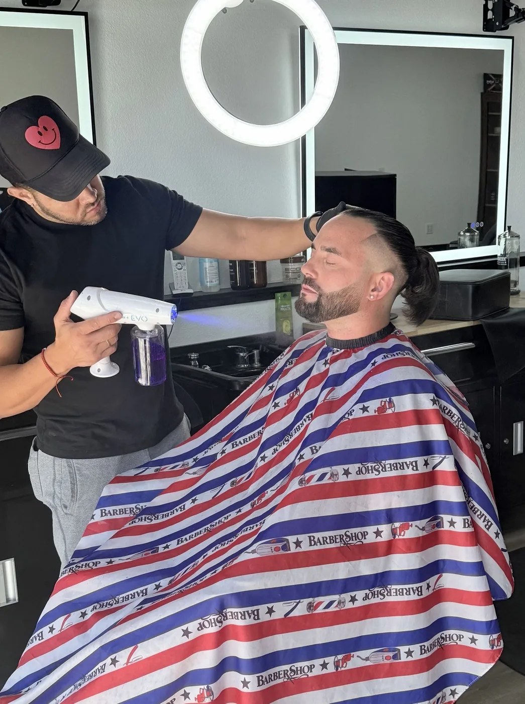 Barber spraying a client's face before a shave