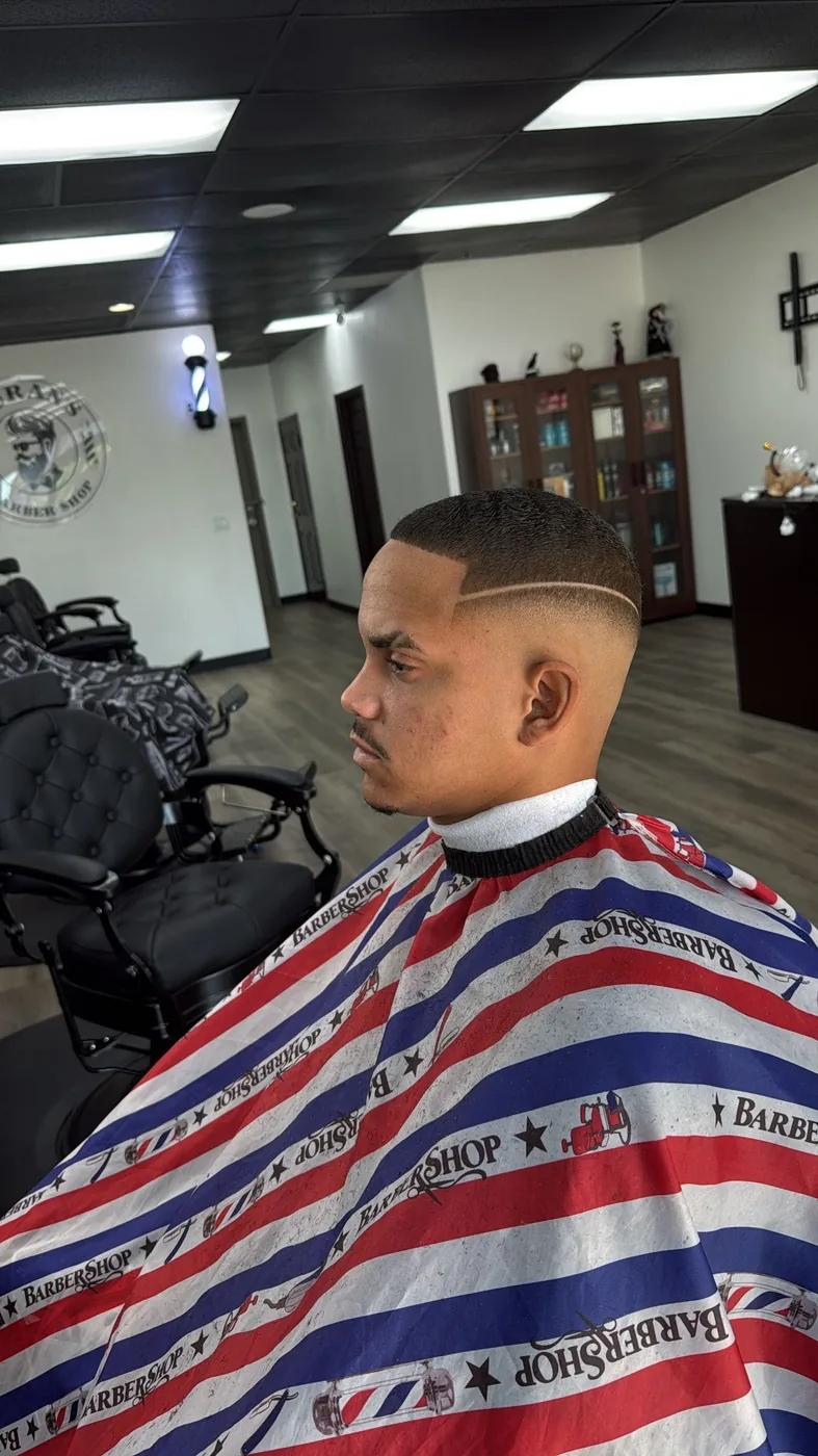 High skin fade with a shaved line above the ear