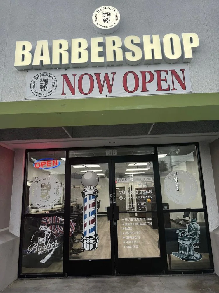 The storefront of Duran's Barbershop with the NOW OPEN banner
